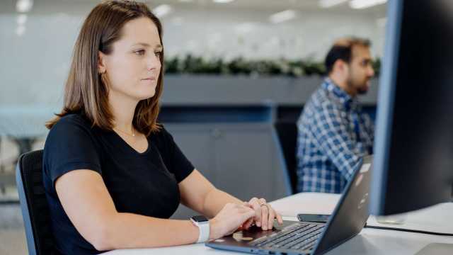 Female staff using computer sitting at desk_122091-56