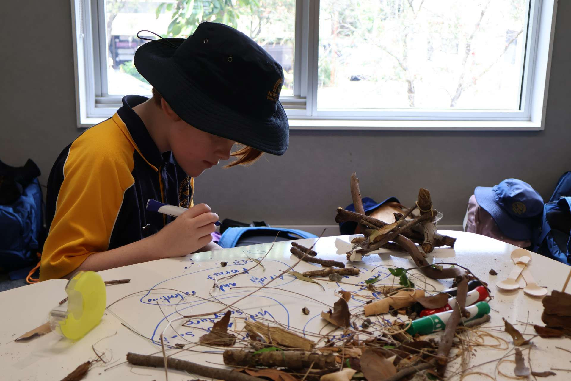 Co design of play facilities underway, child with pen and nature based sculpture of dream play area